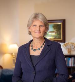 President Bradley wearing a green multi stone necklace and blue jacket