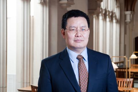 Haoming Liu wearing a blue shirt, navy jacket and red patterned tie. 