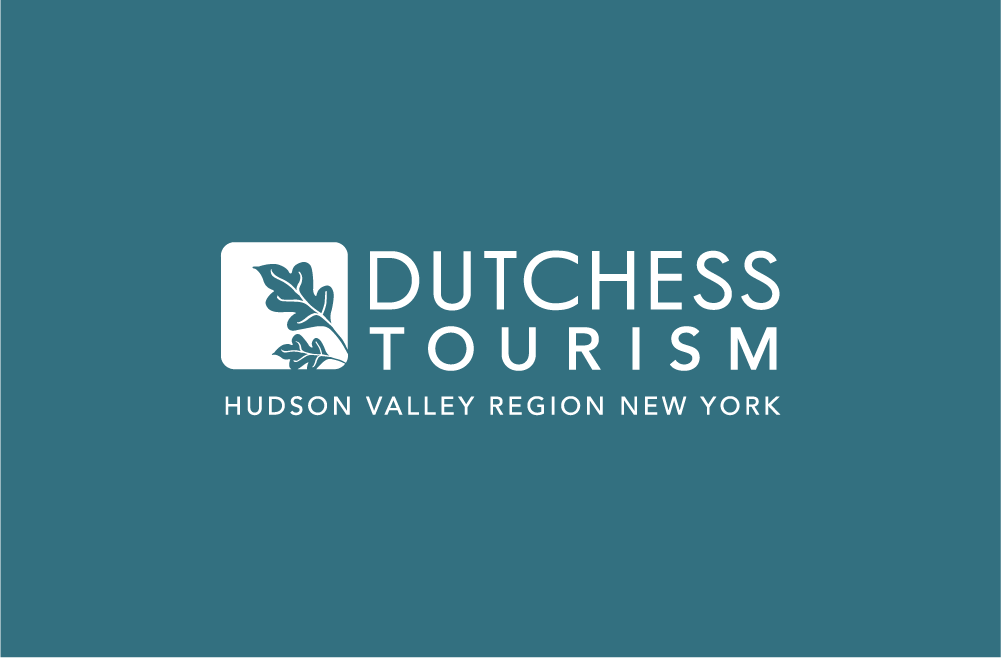 Dutchess Tourism logo, white sans serif font on a blue background with an outlined image of leaves to the left.