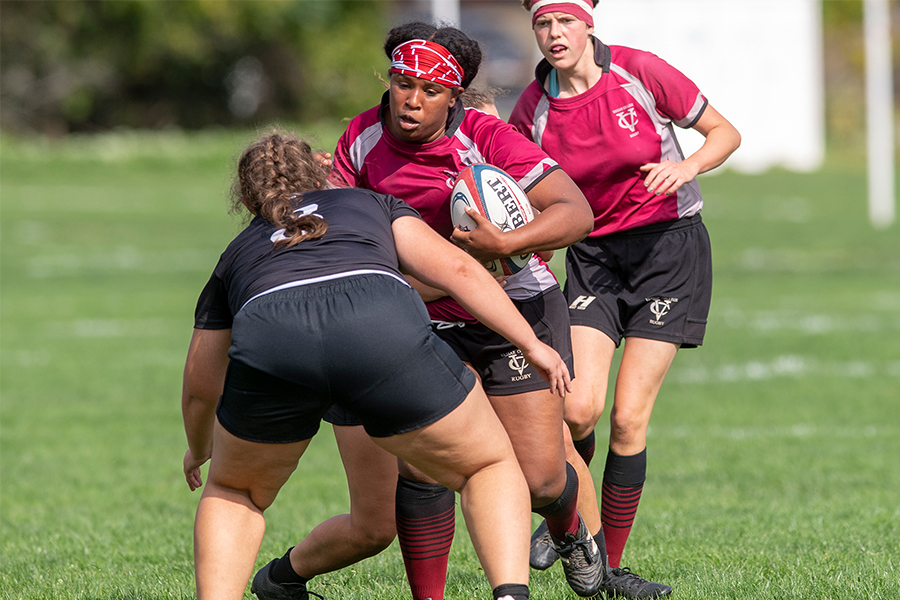 Asia Baker, holding the ball, tries to push past a member of the opposing team.