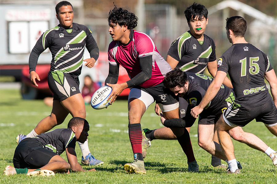 Hector Contreras, holding the ball, is tackled by members of the opposing team.