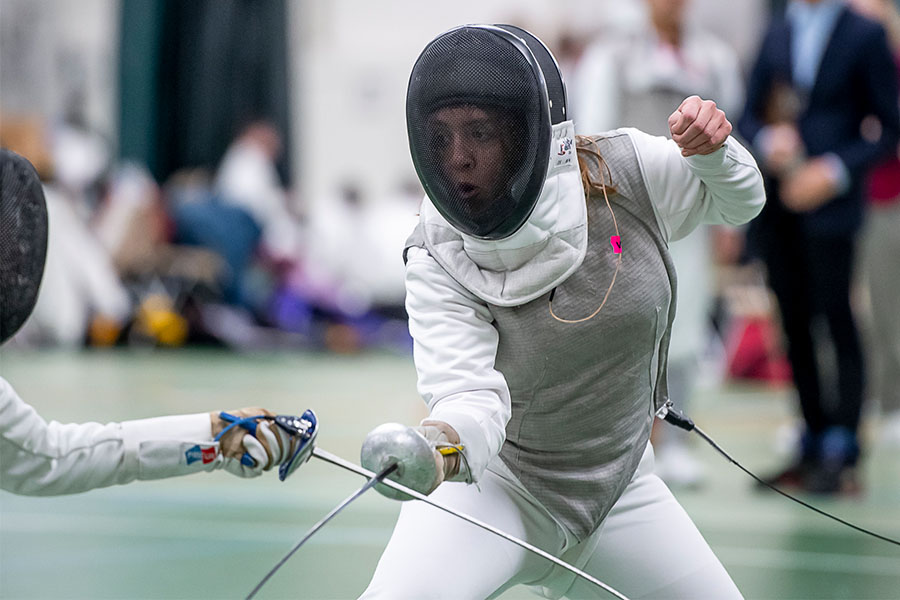 During a match, Hunter Grogan ’24 crosses swords with an opponent.