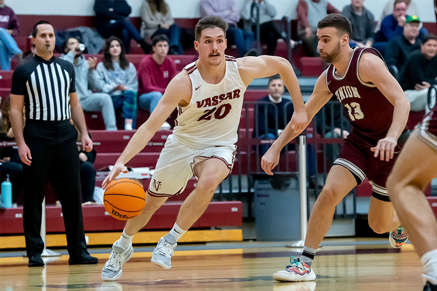 Jack Rothenberg ’23 dribbles down the court while fending off an opposing team member.