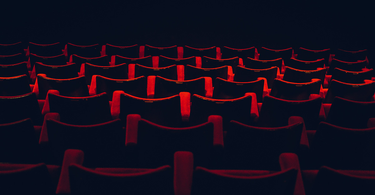 Red seats in rows in a movie theater.
