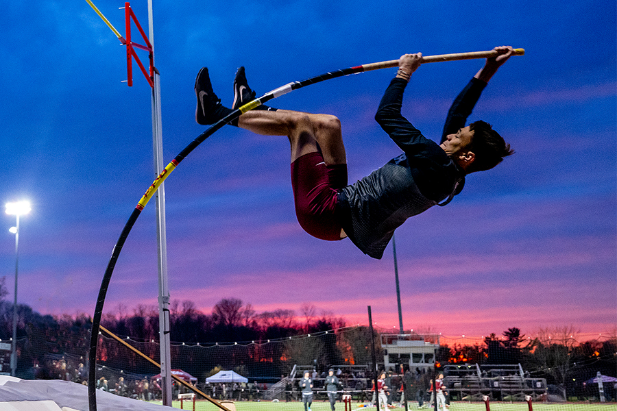 Rey Claro hangs on a bending pole, a glowing sunset in the background.