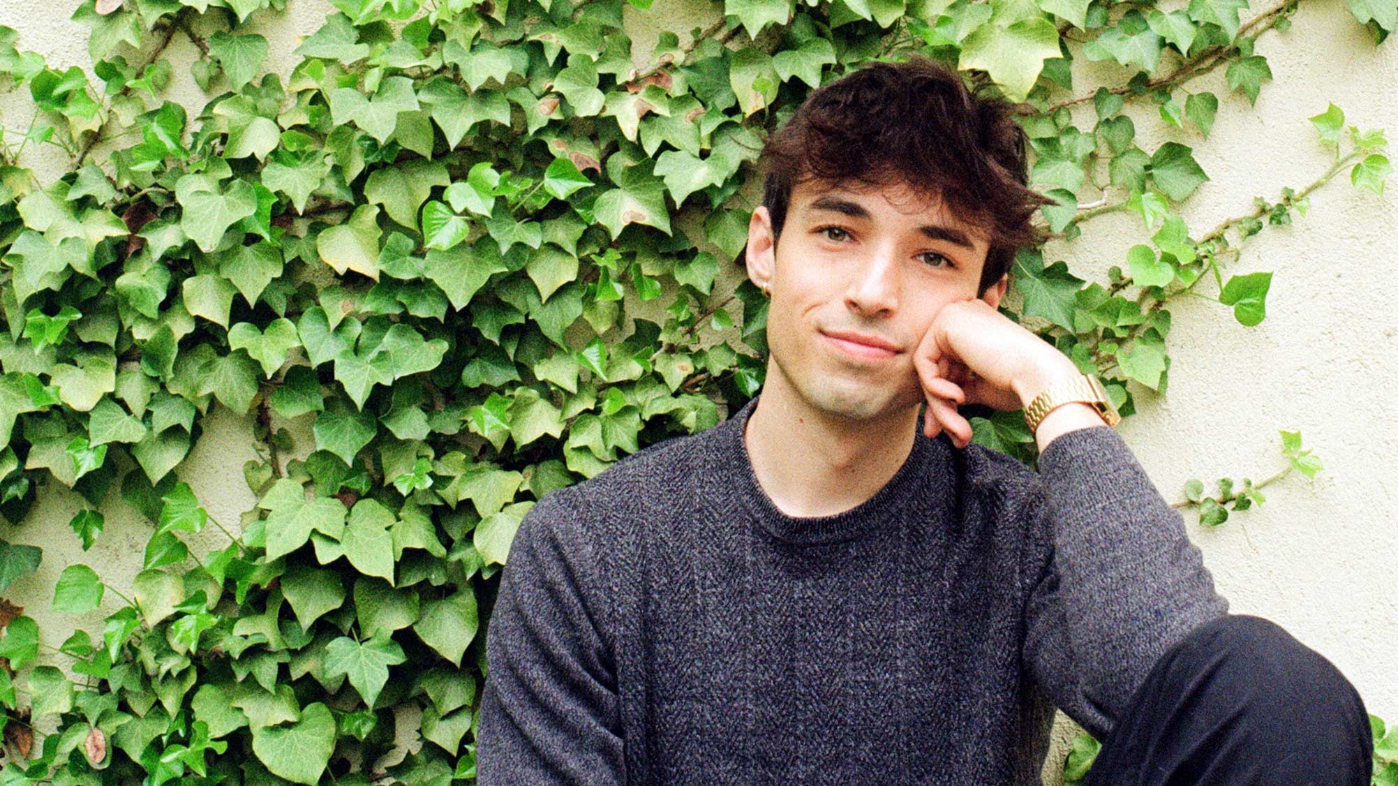 Will Dwyer poses in front of an ivy wall.