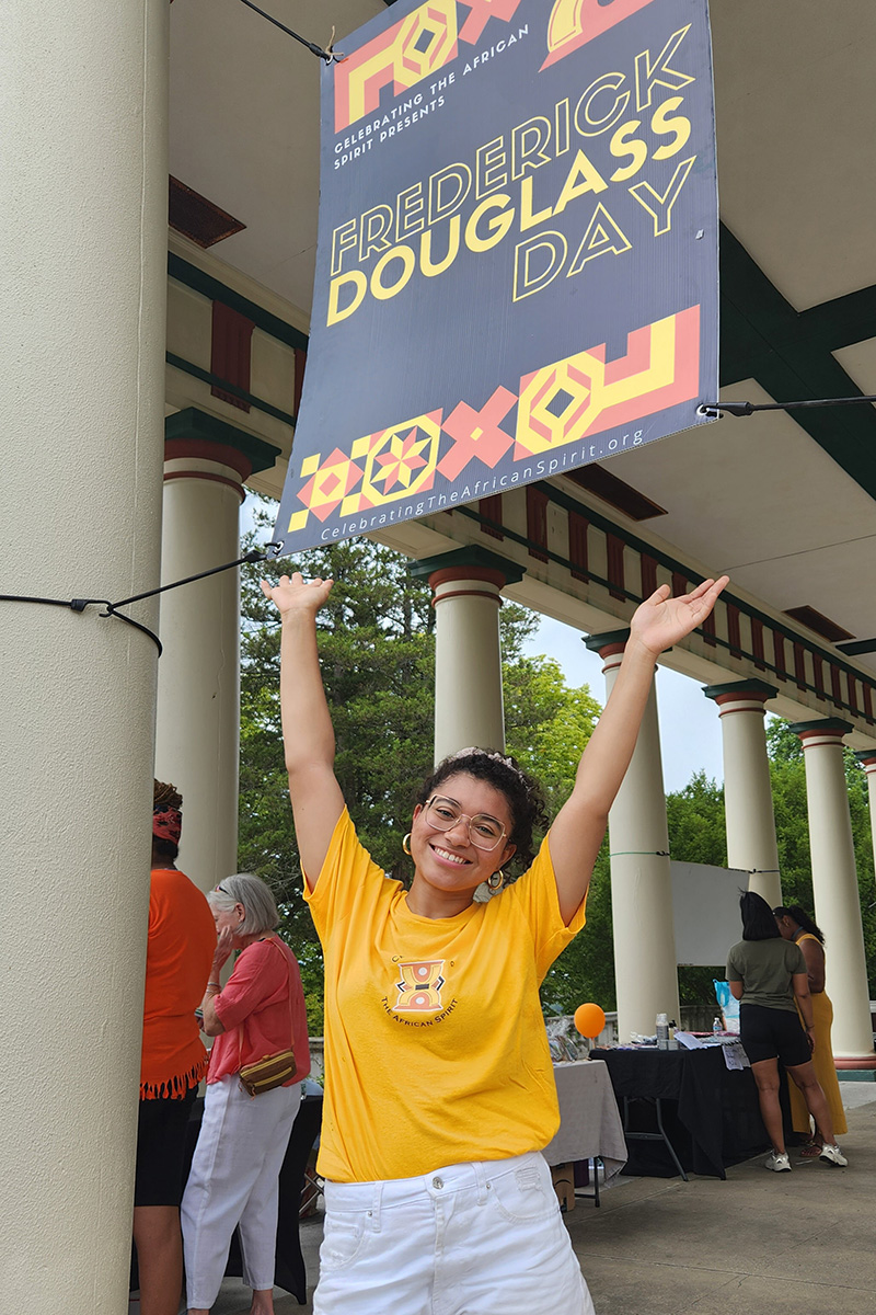 Woman standing outside in a group holding a banner over her head