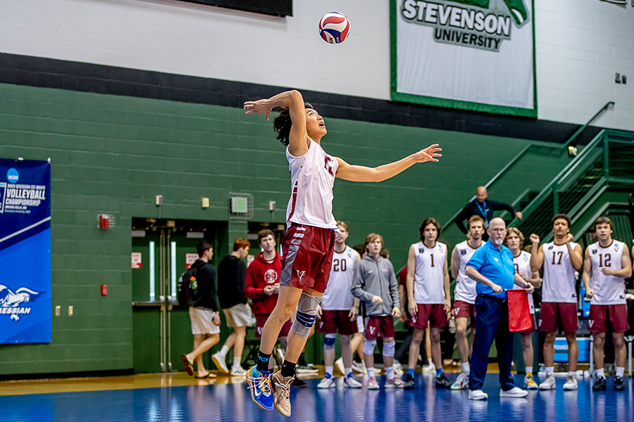 Action shot of Jacob Kim jumping up to hit the volleyball.