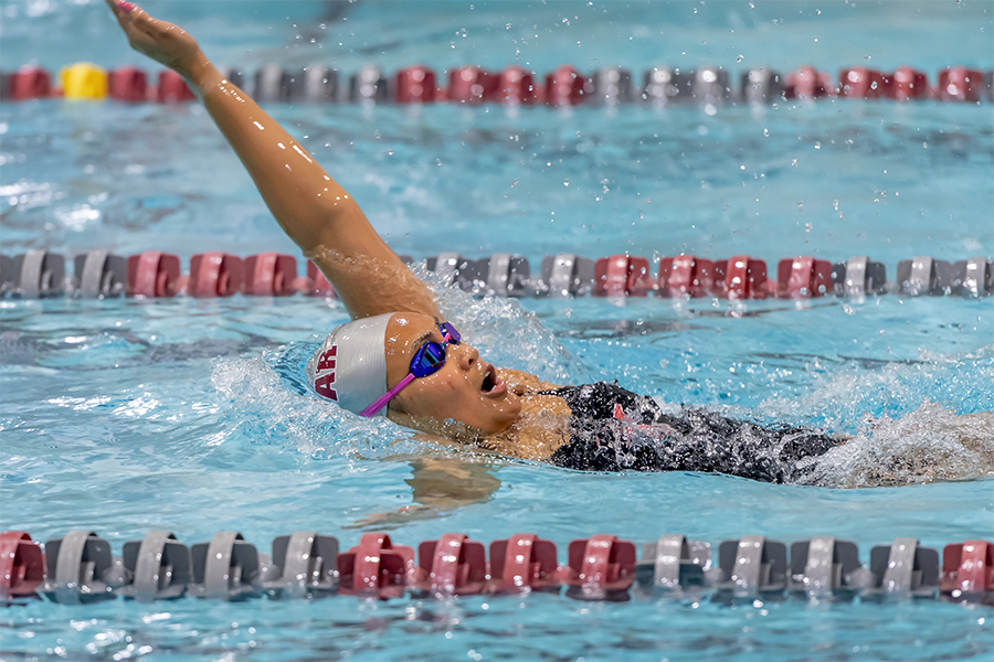 Action shot of Sarah Quintana swimming the backstroke in a pool.