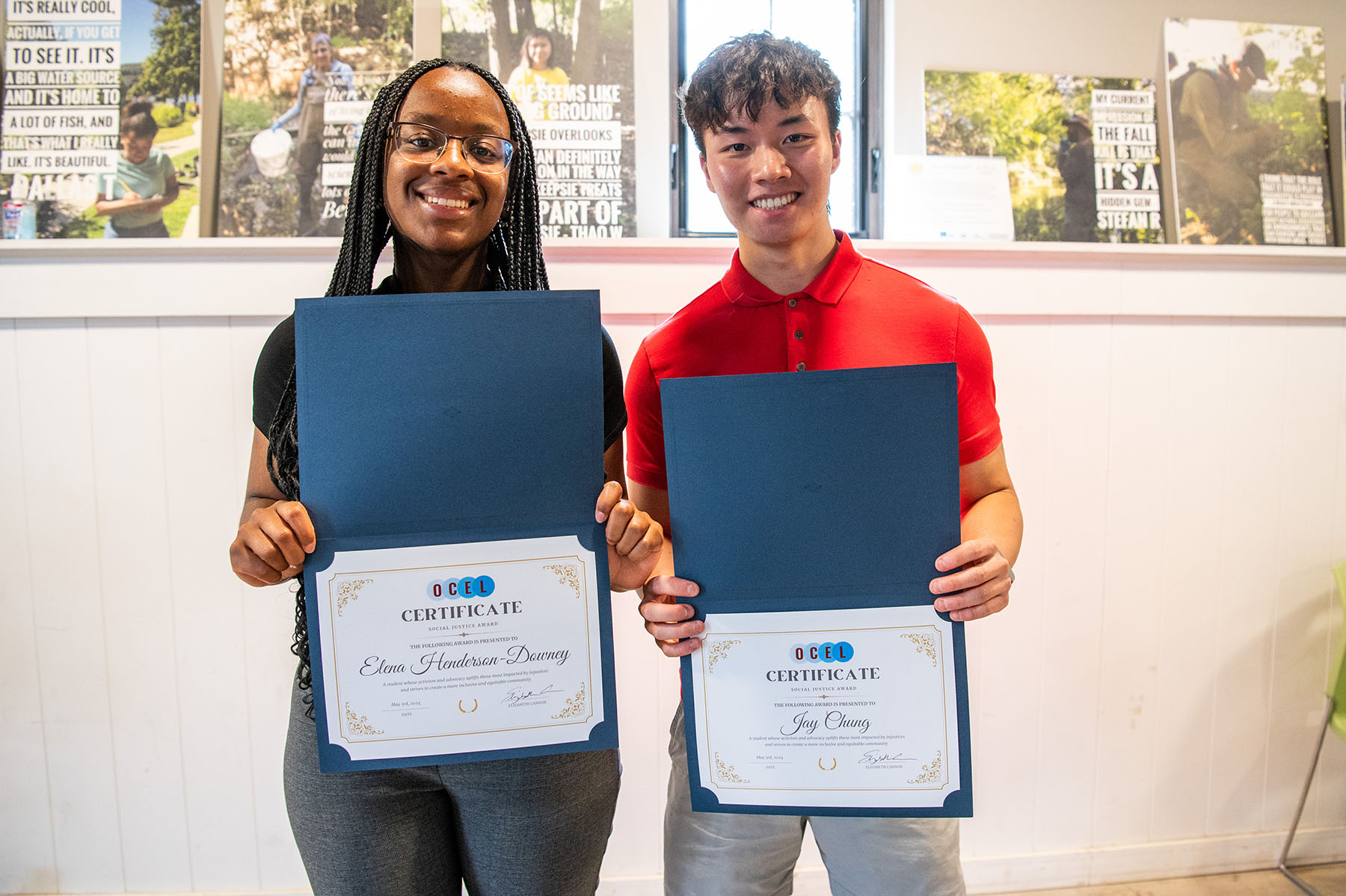 Two people holding diploma/awards and smiling.