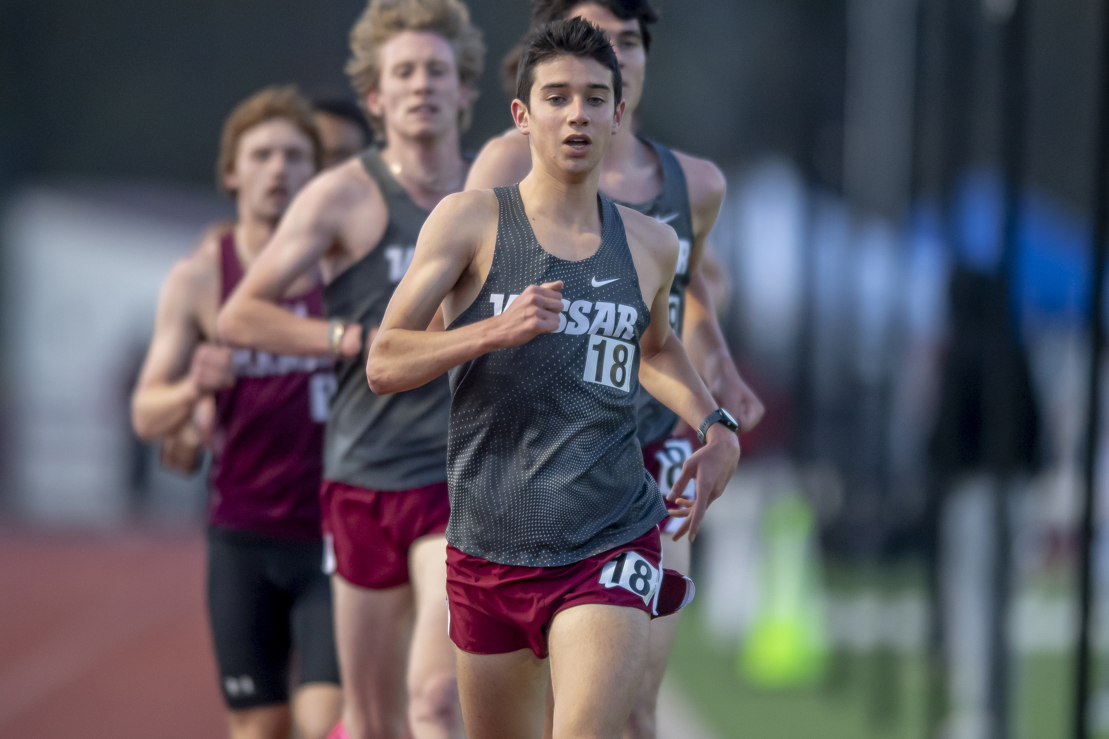 Miles Takiguchi runs ahead of several competitors during a track meet.