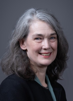 A headshot of Elizabeth Hoffman, a person with long gray hair and a dark jacket.