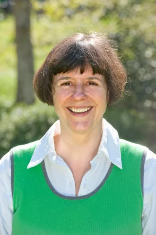 A headshot of Dr. Sabine Rolle, a person with short brown hair and a green vest.