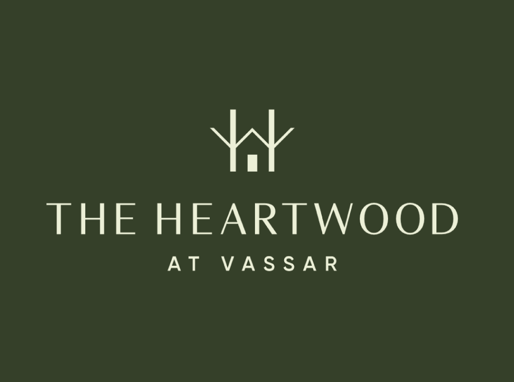 Cream colored logo and text on a green background. Logo is a house and trees and the text reads: The Heartwood at Vassar.