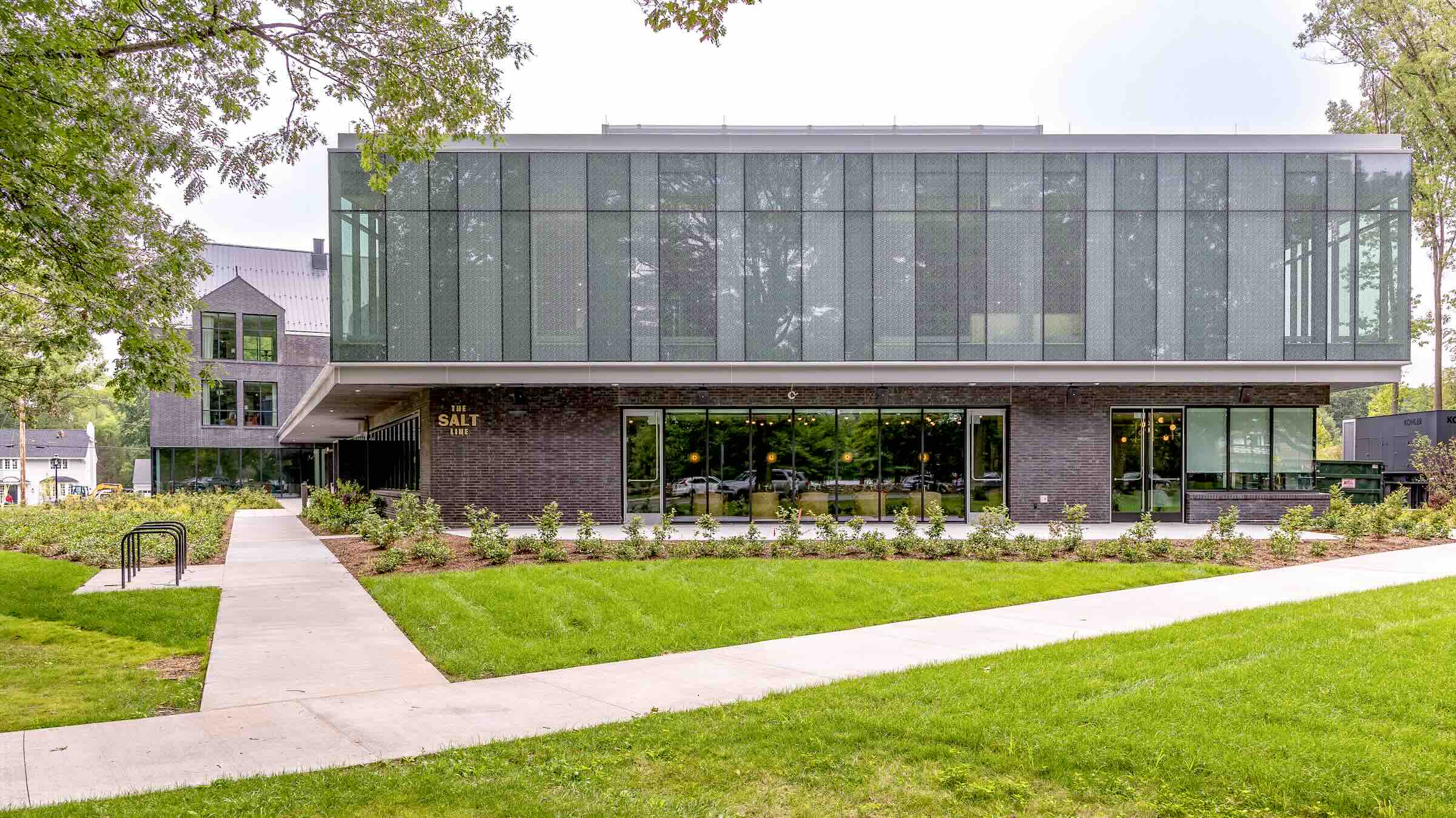 Exterior shot of a glass and metal building with large windows looking into an event space.