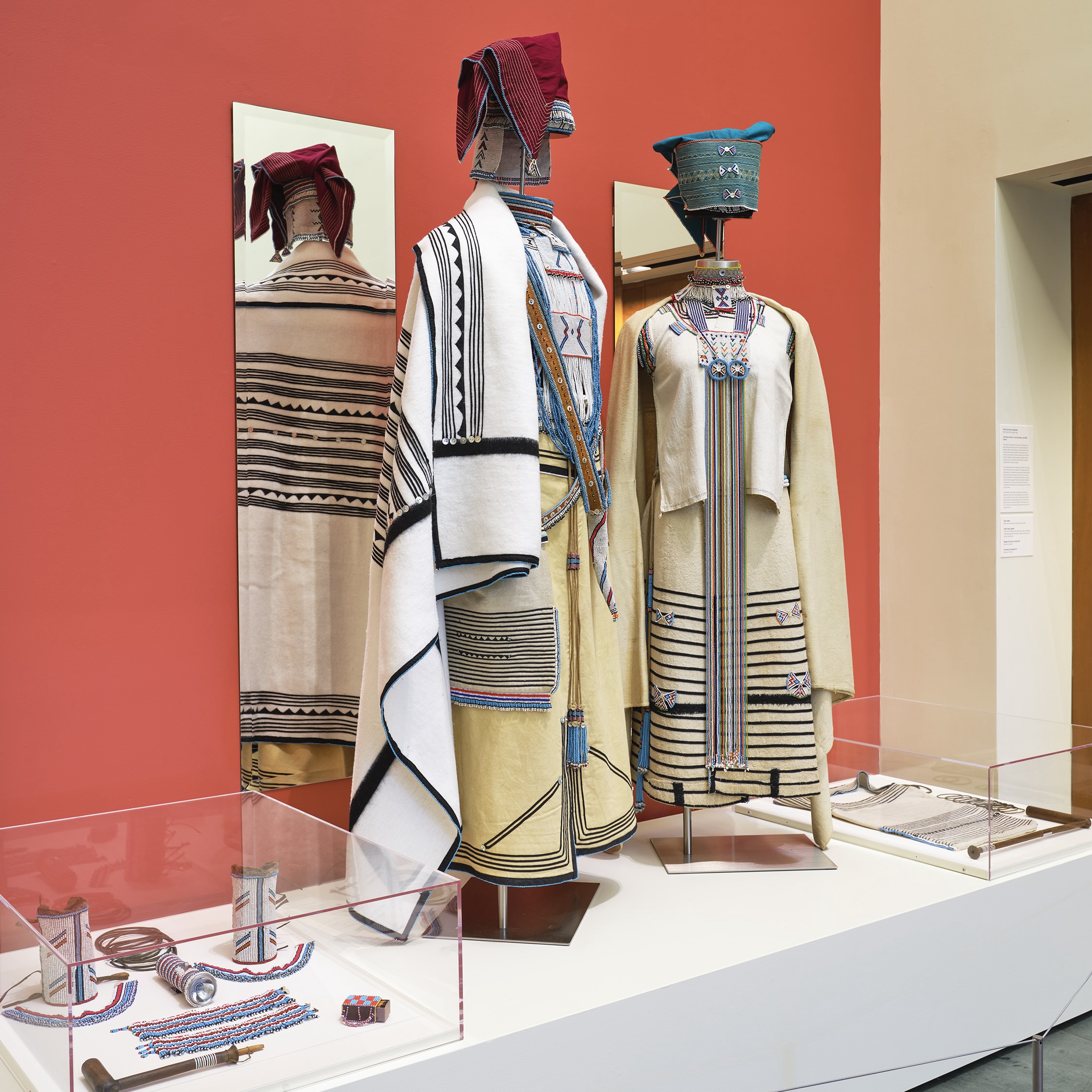 Museum display of two traditional Xhosa beaded ceremonial outfits.