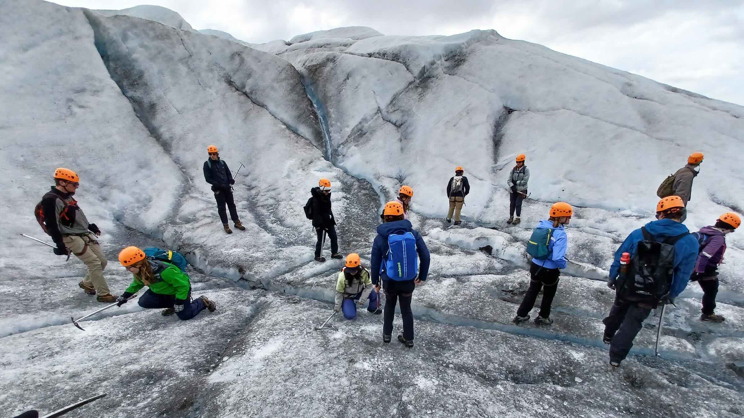 Group of people walking on a glacier.