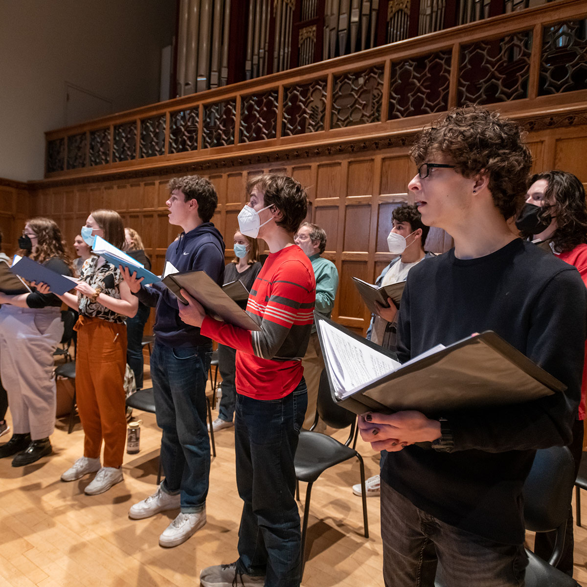 People in a choir on stage singing.