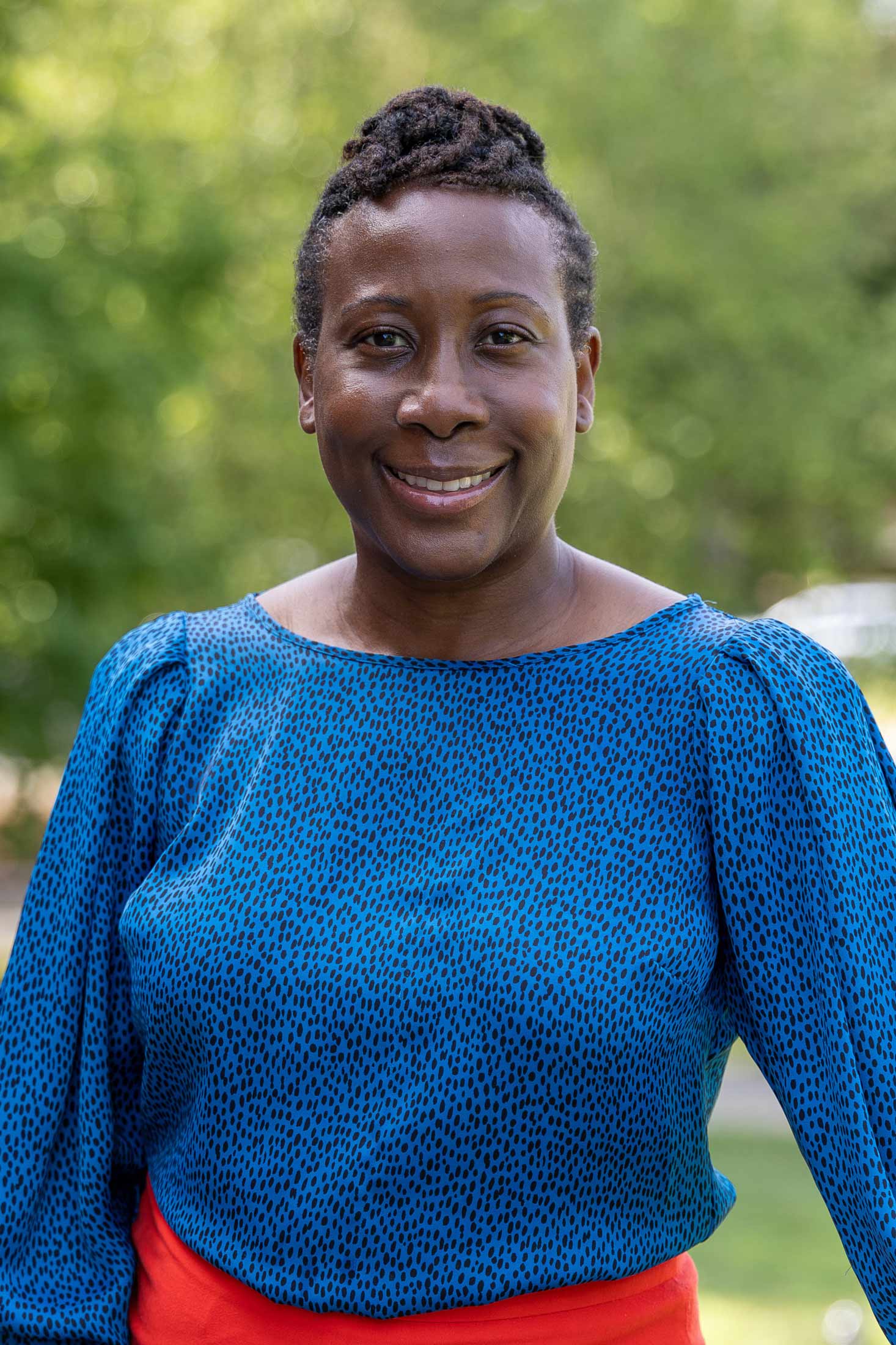 A portrait photo of Kimberly Williams-Brown standing outside.