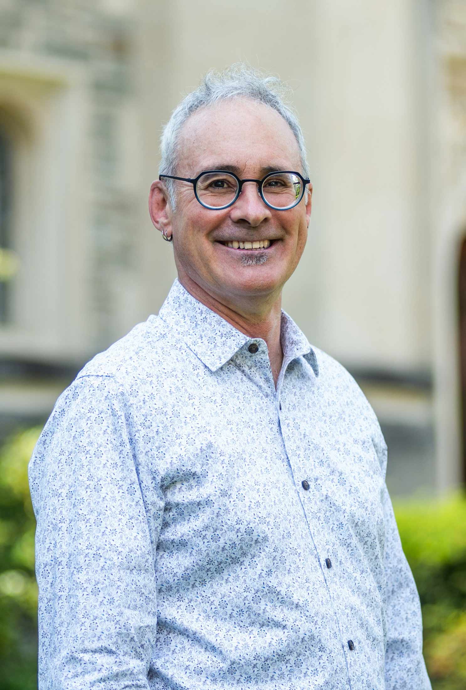 A portrait photo of Jeffrey Schneider standing outside.