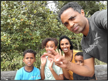 A family standing outside in the wilderness posing for a photo.