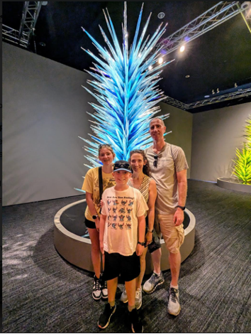 Four people standing in front of an artistic display in a museum.