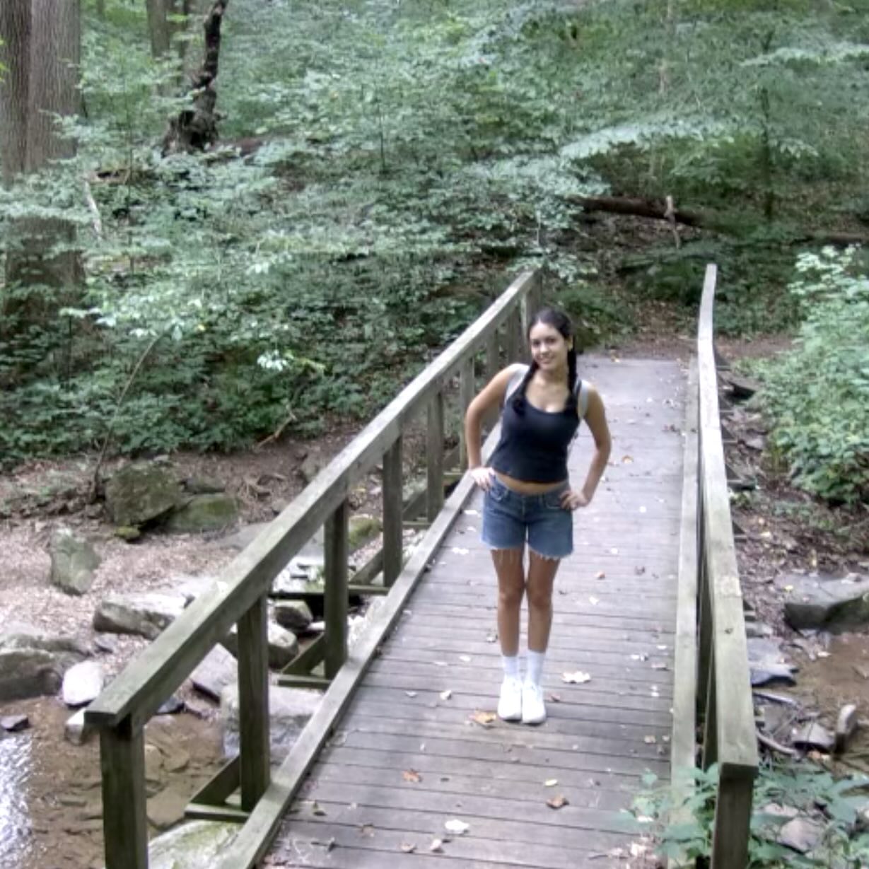 A photo of Sofia Rojas Collins, a person with long dark hair, a tank top, and denim shorts.