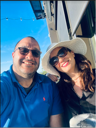 Two people sitting outside smiling while wearing sub glasses.