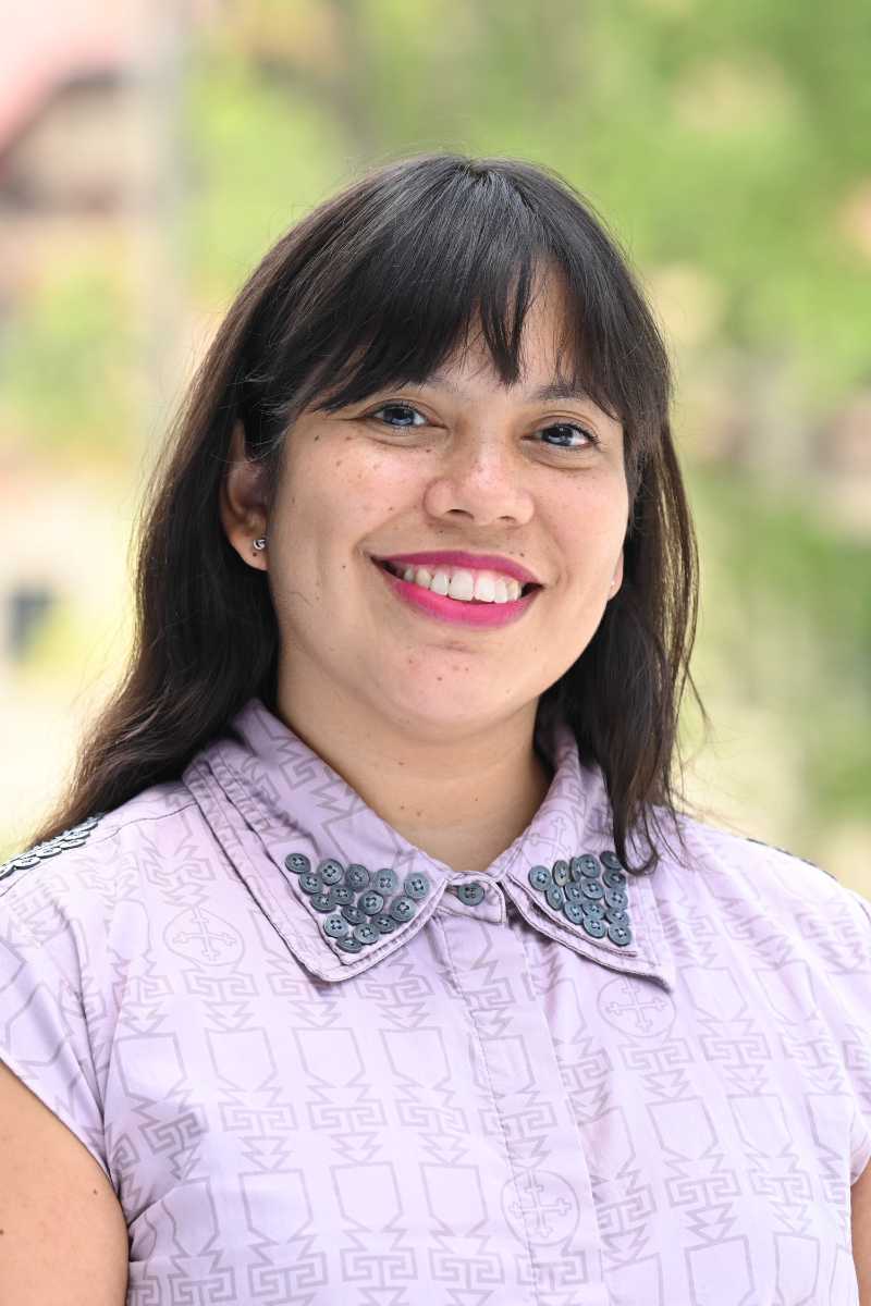 A portrait of Tania Barrenechea Barreda, a person with long black hair and a lavender shirt.