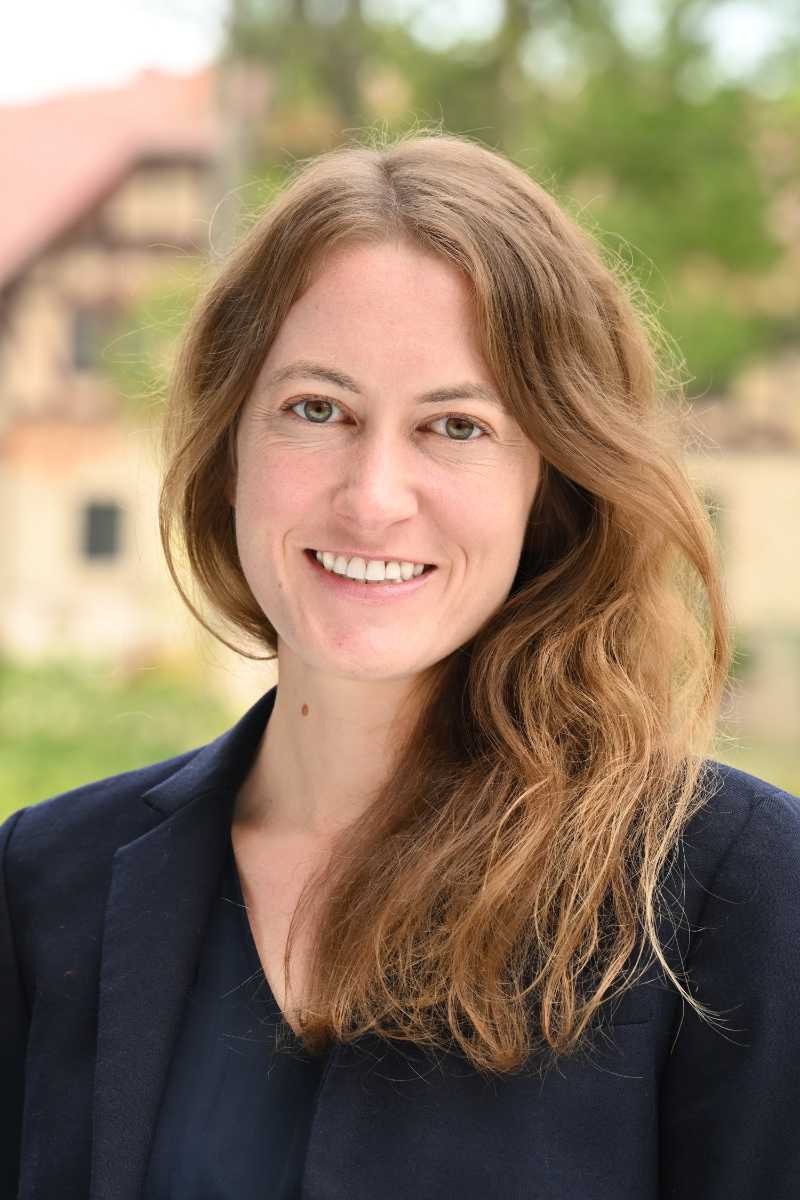 A portrait of Emily Nardoni, a person with long blond hair and a dark blue shirt.