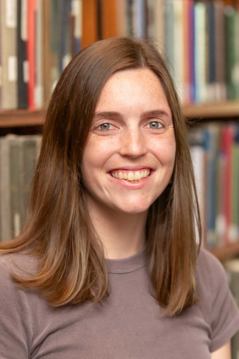 A portrait of Robin Belton, a person with long brown hair and a brown shirt.