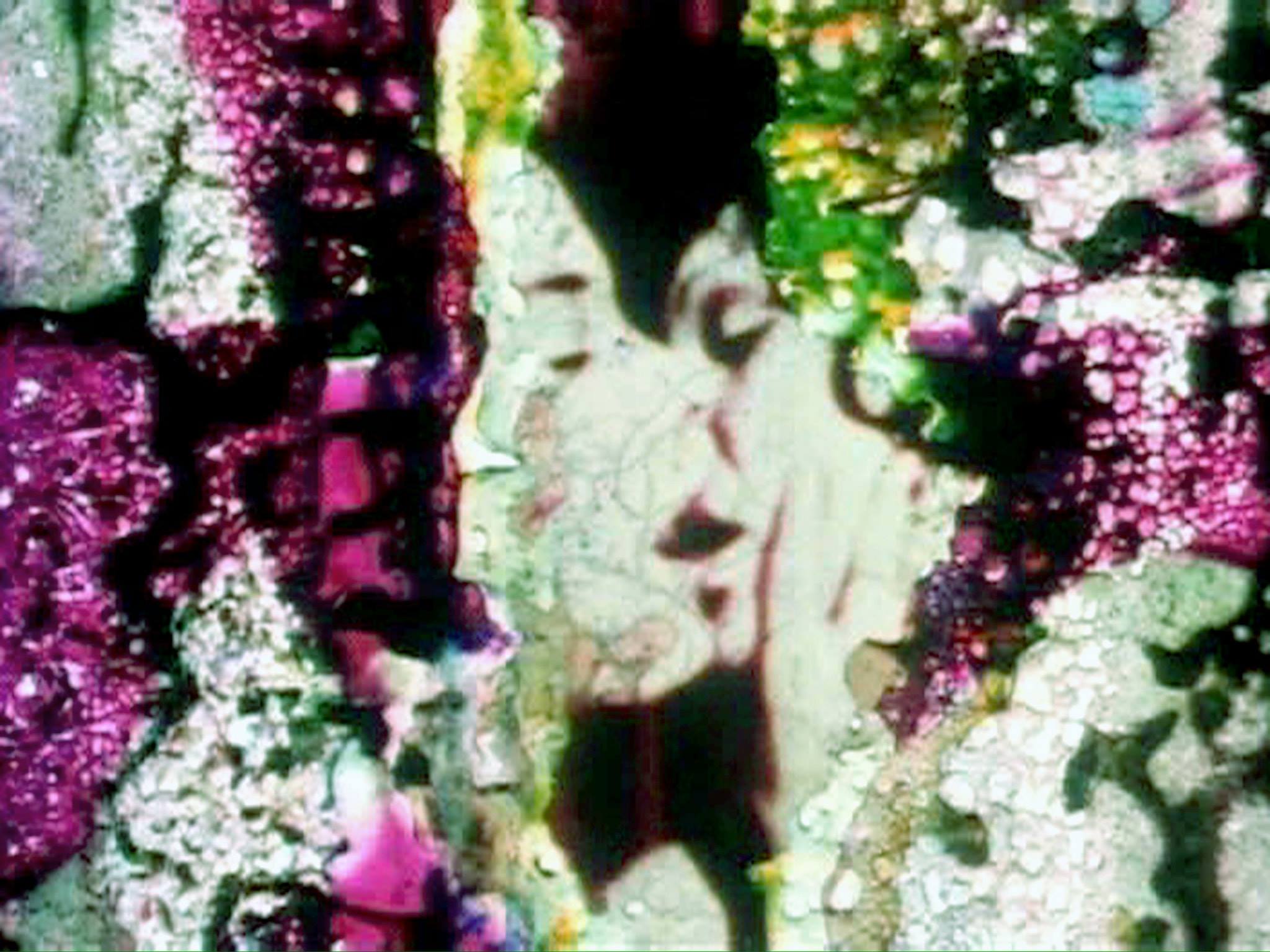 an image of degraded celuloid film, two women kiss with the damaged edges hand painted.