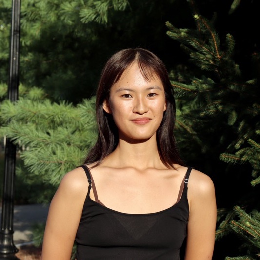 A portrait of Lillian Liu, a person with long dark brown hair and a black tank top.