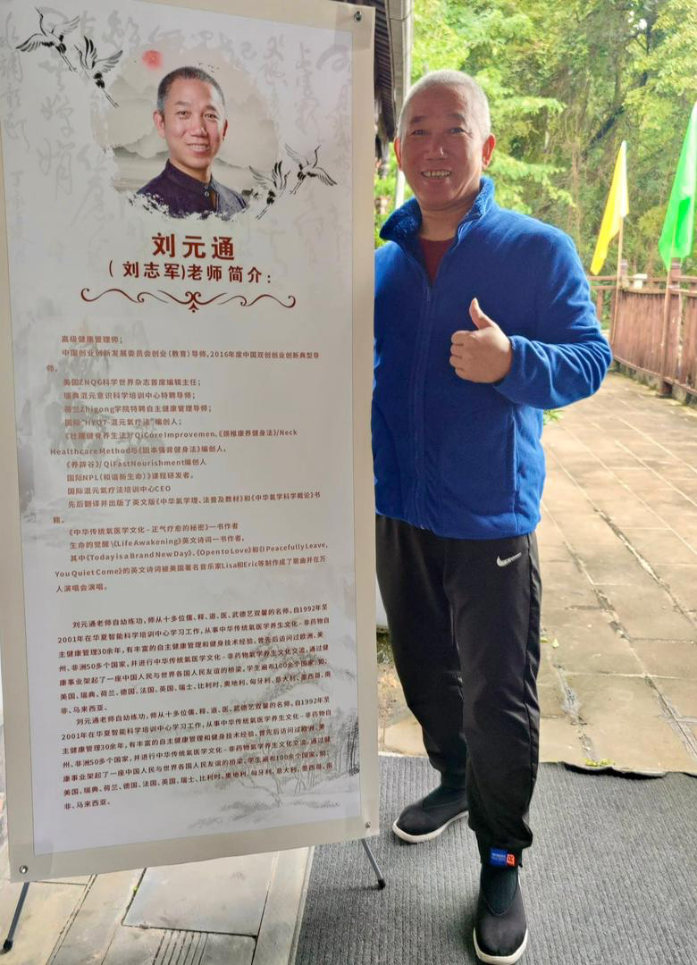 A person in a blue shirt giving a thumbs up standing next to a large parchment with writing and a picture at the top.