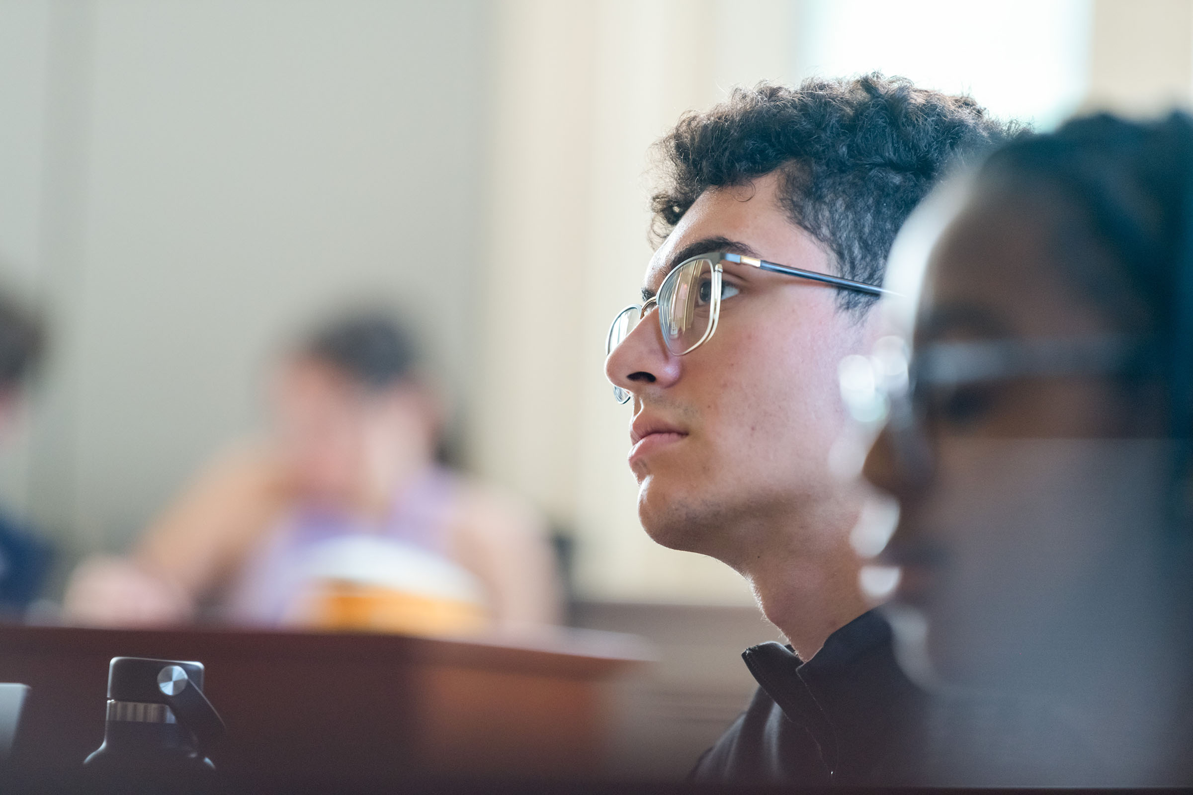 View of the left side of two people's head, both wearing eyeglasses.