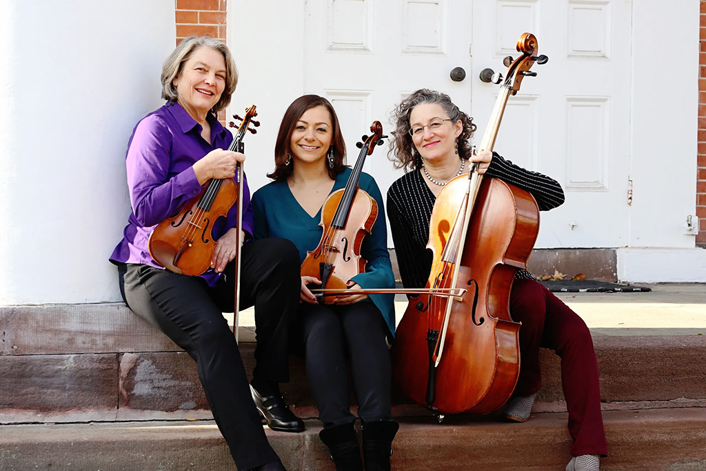 The three artists posing with their instruments.