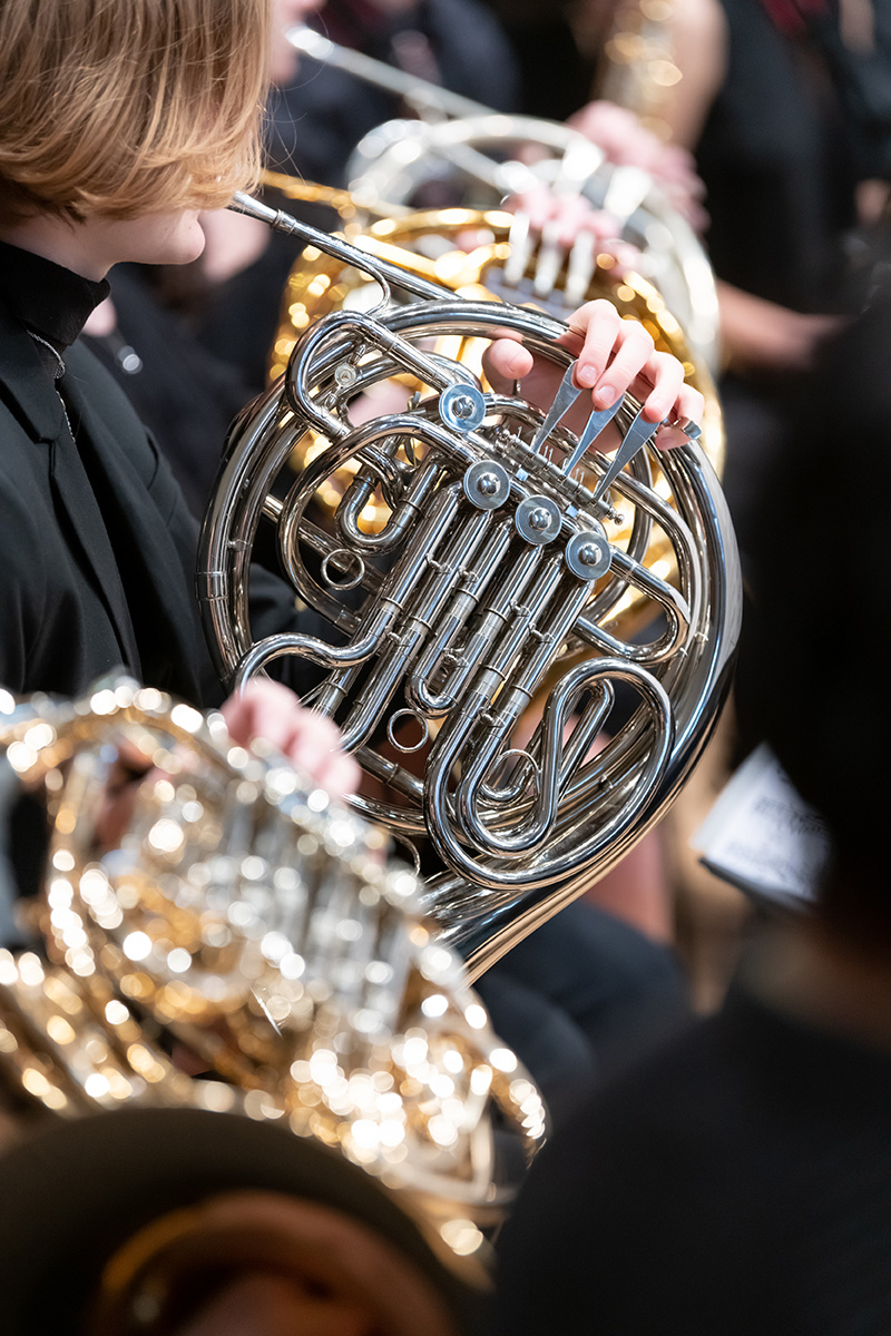 Closeup of performer playing French horn