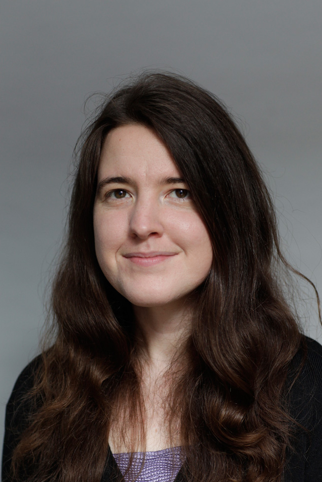 Portrait of a person with long brown hair and a black sweater.