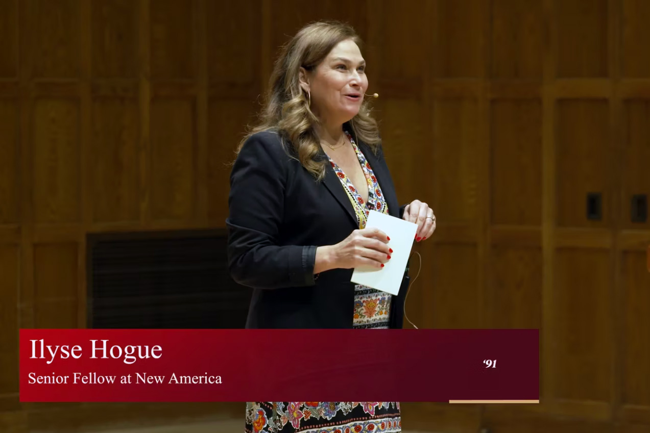 Video still of a person lecturing on a stage with a text overlay that reads: Ilyse Hogue ’91 Senior Fellow at New America.