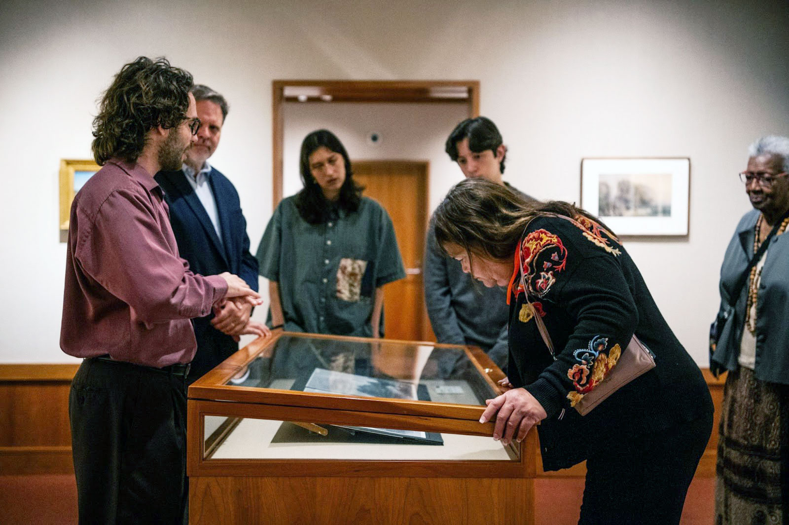 People in a museum gallery looking into a glass case.