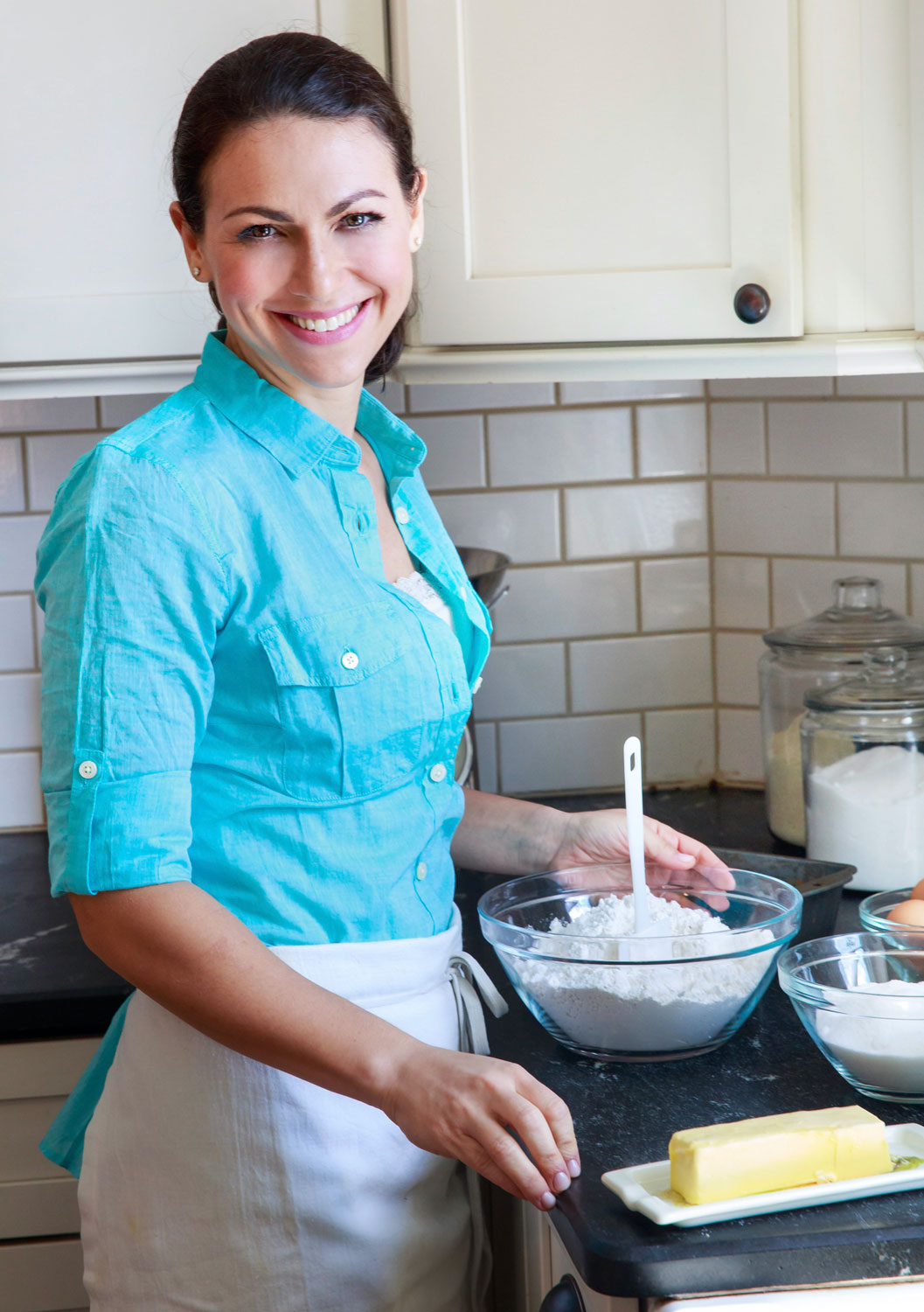 Photo of Elisa Strauss in an apron in front of baking materials.