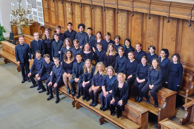 An aerial image of the choir assembled on bleachers