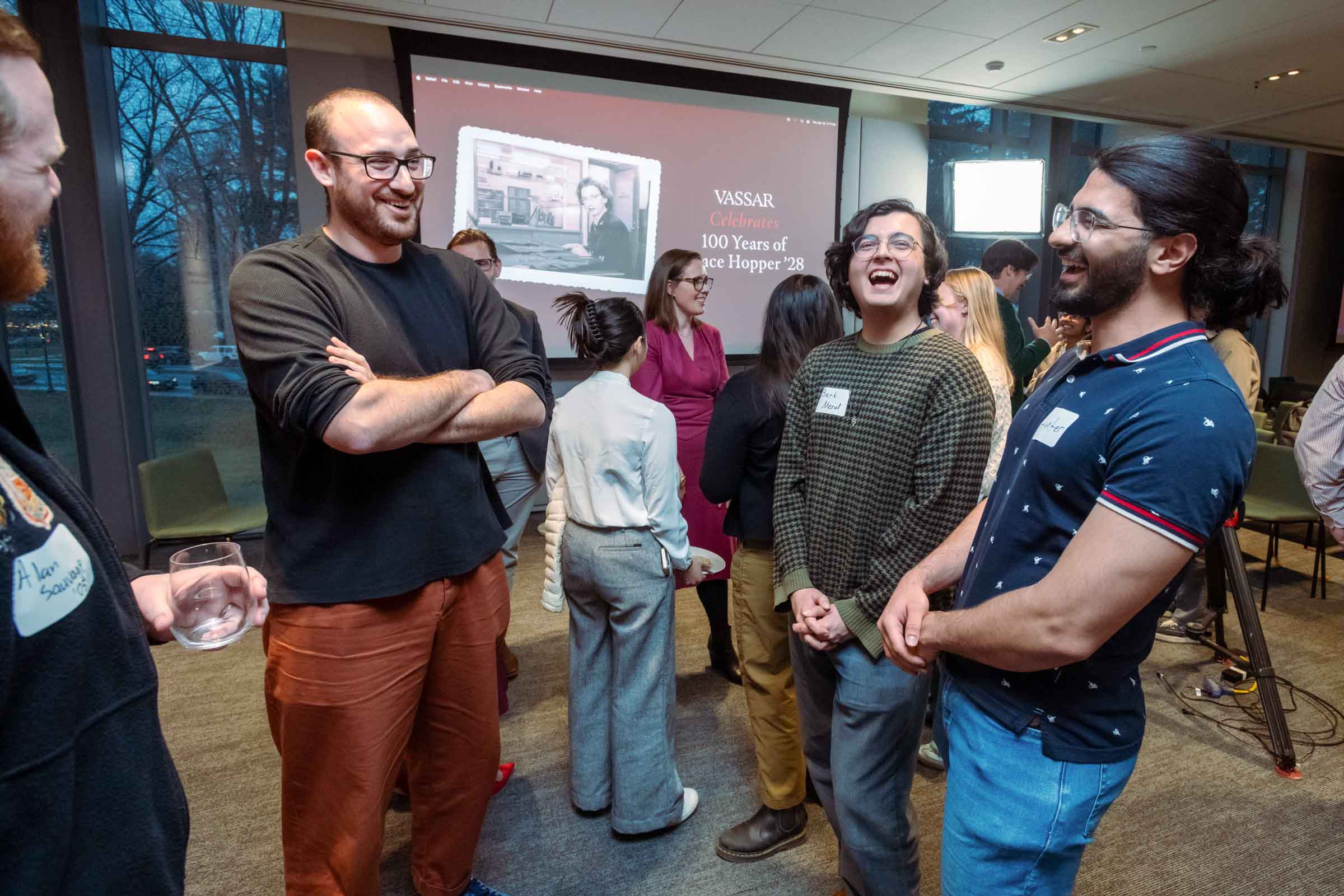 Group of people standing in a semi-circle laughing out loud.