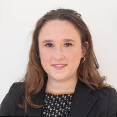 Juliet Weis headshot wearing a black printed shirt and black jacket