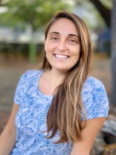 Cara Chaudron wearing a blue and white patterned shirt and has long light colored hair.