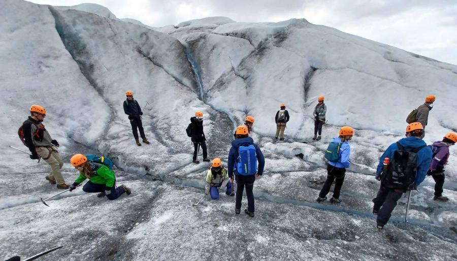 Group of people walking on a glacier.