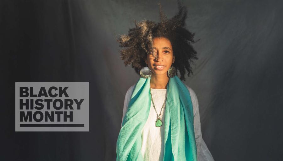 Alexis Pauline Gumb poses in front of a grey background, with a 'Black History Month' badge overlaid.