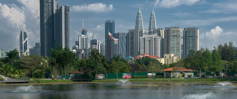 View of Kuala Lumpur skyline as seen from Tasik Titiwangsa on a blue sky day. Petronas Twin towers are on the right hand side. Malaysia, Apr/23.