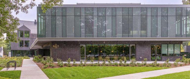 Exterior shot of a glass and metal building with large windows.