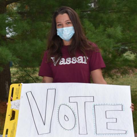 Vassar student holding poster: Vote @VassarVotes